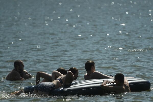 المصطافون على شاطئ منطقة ميشيرسكويه للترفيه والاستجمام في موسكو - سبوتنيك عربي