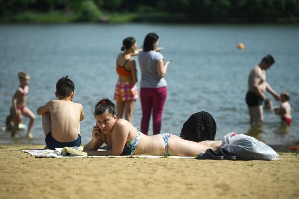 المصطافون على شاطئ منطقة ميشيرسكويه للترفيه والاستجمام في موسكو - سبوتنيك عربي