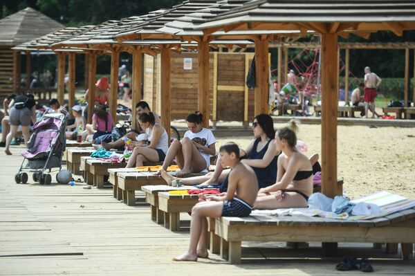 المصطافون على شاطئ منطقة ميشيرسكويه للترفيه والاستجمام في موسكو - سبوتنيك عربي