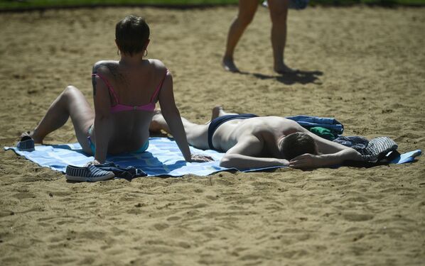 المصطافون على شاطئ منطقة ميشيرسكويه للترفيه والاستجمام في موسكو - سبوتنيك عربي