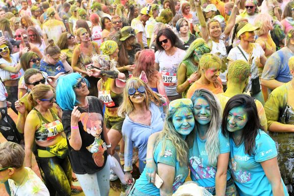 مشاركون أثناء احتفالهم بعد الانتهاء من سباق الألوان (Colour Run 2019) في ملعب لوجنيكي في موسكو، 2 يونيو/ حزيران 2019 - سبوتنيك عربي