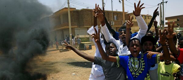 متظاهرون سودانيون يهتفون بشعارات عند أحد المتاريس مطالبين المجلس العسكري الانتقالي في البلاد بتسليم السلطة إلى المدنيين - سبوتنيك عربي