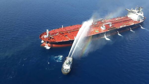 قارب بحرية إيرانية يحاول إيقاف النيران المشتعلة في ناقلة النفط بعد أن تعرضت للهجوم في خليج عمان، 13 يونيو/حزيران 2019 - سبوتنيك عربي