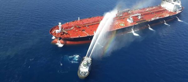 قارب بحرية إيرانية يحاول إيقاف النيران المشتعلة في ناقلة النفط بعد أن تعرضت للهجوم في خليج عمان، 13 يونيو/حزيران 2019 - سبوتنيك عربي