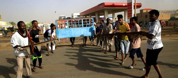 متظاهرون سودانيون يقيمون حاجزًا في أحد الشوارع ويطالبون المجلس العسكري الانتقالي في البلاد بتسليم السلطة إلى المدنيين - سبوتنيك عربي