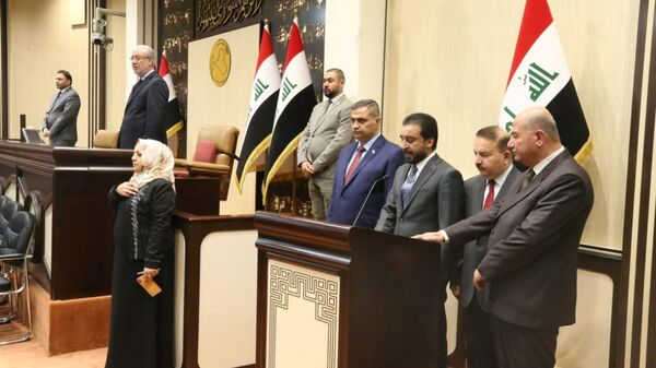 رئيس البرلمان العراقي محمد الحلبوسي يقف مع الوزراء المفوضين حديثاً خلال مراسم أداء اليمين في مقر البرلمان في بغداد - سبوتنيك عربي