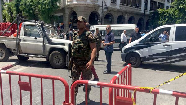 أحد أفراد قوات الأمن يقوم بتأمين موقع انفجار في شارع شارل ديغول بوسط تونس - سبوتنيك عربي