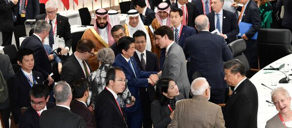 رئيس الوزراء الياباني شينزو آبي يصافح رئيس الوزراء الكندي جاستن ترودو خلال الجلسة الختامية لقمة قادة مجموعة العشرين في أوساكا - سبوتنيك عربي