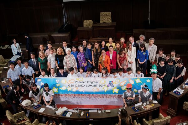 آكي آبي زوجة رئيس وزراء اليابان تلتقط صورة جماعية مع زوجات قادة مجموعة العشرين والأطفال خلال ندوة في أوساكا - سبوتنيك عربي