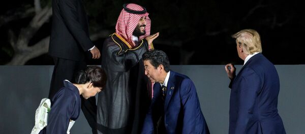 رئيس الوزراء الياباني شينزو آبي يتفقد موقعه مع زوجته آكي آبي حيث يتحدث ولي العهد السعودي الأمير محمد بن سلمان إلى الرئيس الأمريكي دونالد ترامب أثناء جلسة تصوير جماعية أمام قلعة أوساكا في قمة مجموعة العشرين في أوساكا باليابان - سبوتنيك عربي