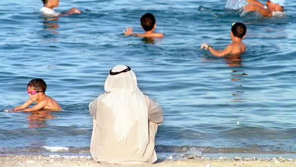 مواطن كويتي يراقب الأطفال وهم يسبحون في البحر بالكويت بالتزامن مع ارتفاع درجات الحرارة في البلاد مواطن كويتي يراقب الأطفال وهم يسبحون في البحر بالكويت بالتزامن مع ارتفاع درجات الحرارة في البلاد - سبوتنيك عربي