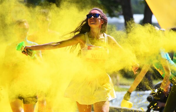 مشاركون يلقون مسحوقًا ملونًا أثناء احتفالهم بعد الانتهاء من سباق الألوان (Colour Run 2019) في ملعب لوجنيكي في موسكو، 2 يونيو/ حزيران 2019 - سبوتنيك عربي