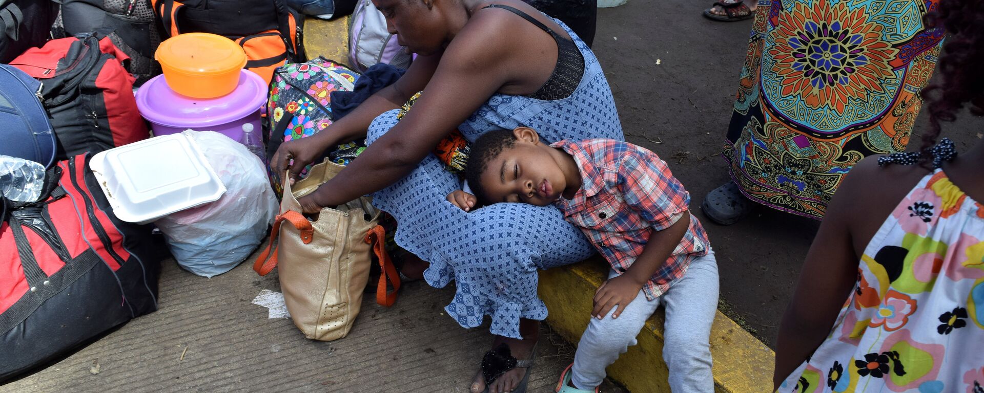 مهاجرون من الكاميرون يستريحون أثناء انتظارهم مع مهاجرين آخرين من أفريقيا وهايتي لدخول مركز احتجاز المهاجرين - سبوتنيك عربي, 1920, 10.01.2022