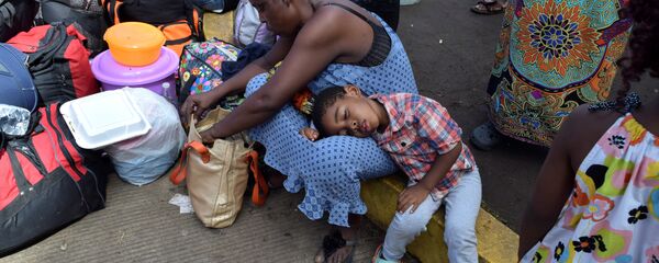 مهاجرون من الكاميرون يستريحون أثناء انتظارهم مع مهاجرين آخرين من أفريقيا وهايتي لدخول مركز احتجاز المهاجرين - سبوتنيك عربي