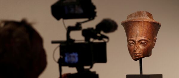 مصور يلتقط صورة لرأس توت عنخ آمون قبل بيعها في دار كريستيز للمزادات في لندن - سبوتنيك عربي