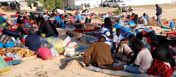 المهاجرون وهم يحملون أمتعتهم في ساحة مركز احتجاز للمهاجرين الأفارقة الذين أصيبوا في غارة جوية في ضاحية تاجوراء بطرابلس - سبوتنيك عربي