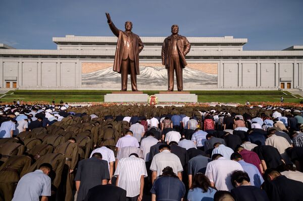 سكان بيونغ يانغ خلال دقيقة صمت أمام النصب التذكاري لكيم إيل سونغ وكيم جونغ إيل في يوم الذكرى الـ 25 لوفاة كيم إم سونغ، بيونغ يانغ، كوريا الشمالية 8 يوليو/ تموز 2019 - سبوتنيك عربي