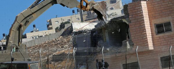 دورية للقوات الإسرائيلية أثناء قيامها بهدم منزل فلسطيني في قرية صور باهر تقع على جانبي الجدار الإسرائيلي في القدس الشرقية والضفة الغربية التي تحتلها إسرائيل - سبوتنيك عربي