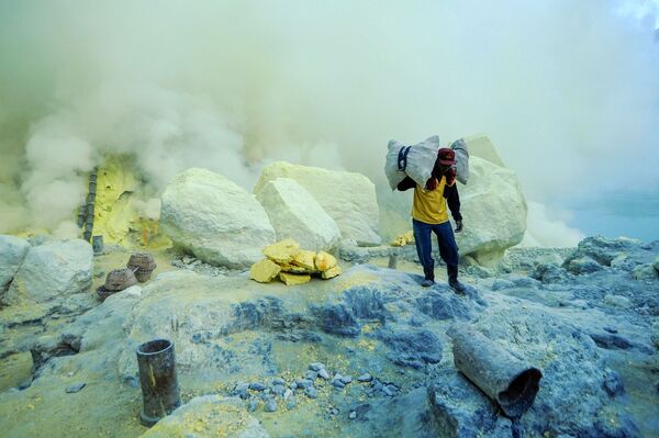 عامل منجم ينقل سلال الكبريت الصلب من مقلع يقع على البركان النشط كواه آيجن (Kawah Ijen) في إندونيسيا. يسود الفقر في المنطقة، والعمال ليس لديهم ملابس خاصة لهذه الوظيفة، ومتوسط الأجور، يتراوح بين 7-8 دولارات في اليوم. يقوم كل عامل منجم بنقل 75-90 كغم من الكبريت من المنجم في رحلة واحدة. - سبوتنيك عربي