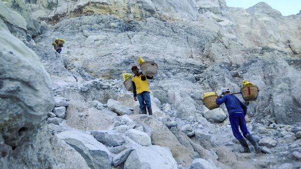 عامل منجم ينقل سلال الكبريت الصلب من مقلع يقع على البركان النشط كواه آيجن (Kawah Ijen) في إندونيسيا. يسود الفقر في المنطقة، والعمال ليس لديهم ملابس خاصة لهذه الوظيفة، ومتوسط الأجور، يتراوح بين 7-8 دولارات في اليوم. يقوم كل عامل منجم بنقل 75-90 كغم من الكبريت من المنجم في رحلة واحدة. - سبوتنيك عربي