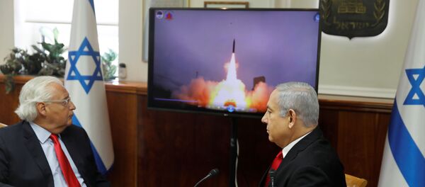 رئيس الوزراء الإسرائيلي بنيامين نتنياهو والسفير الأمريكي لدى إسرائيل ديفيد فريدمان يشاهدان شريط فيديو لدرع الصواريخ الباليستية Arrow-3 المدعوم من الولايات المتحدة الأمريكية أثناء سلسلة من اختبارات الاعتراض الحية خلال اجتماع لمجلس الوزراء في القدس - سبوتنيك عربي