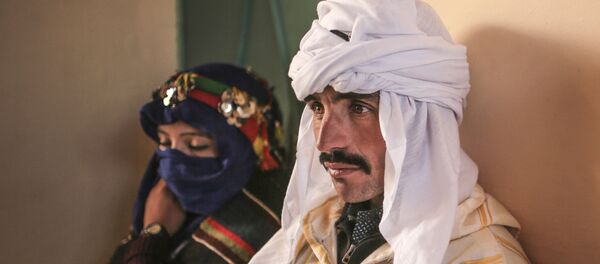 زوجان ينتظران عقد قرانهما خلال مهرجان سنوي في قرية صغيرة في جبال الأطلس في المغرب حيث يجتمع العشرات من الأزواج من أماكن صغيرة جدًا بحيث لا توجد مكاتب حكومية حتى يتم التصديق على زيجاتهم بينما يأمل الشباب الآخرون في العثور على شركاء - سبوتنيك عربي