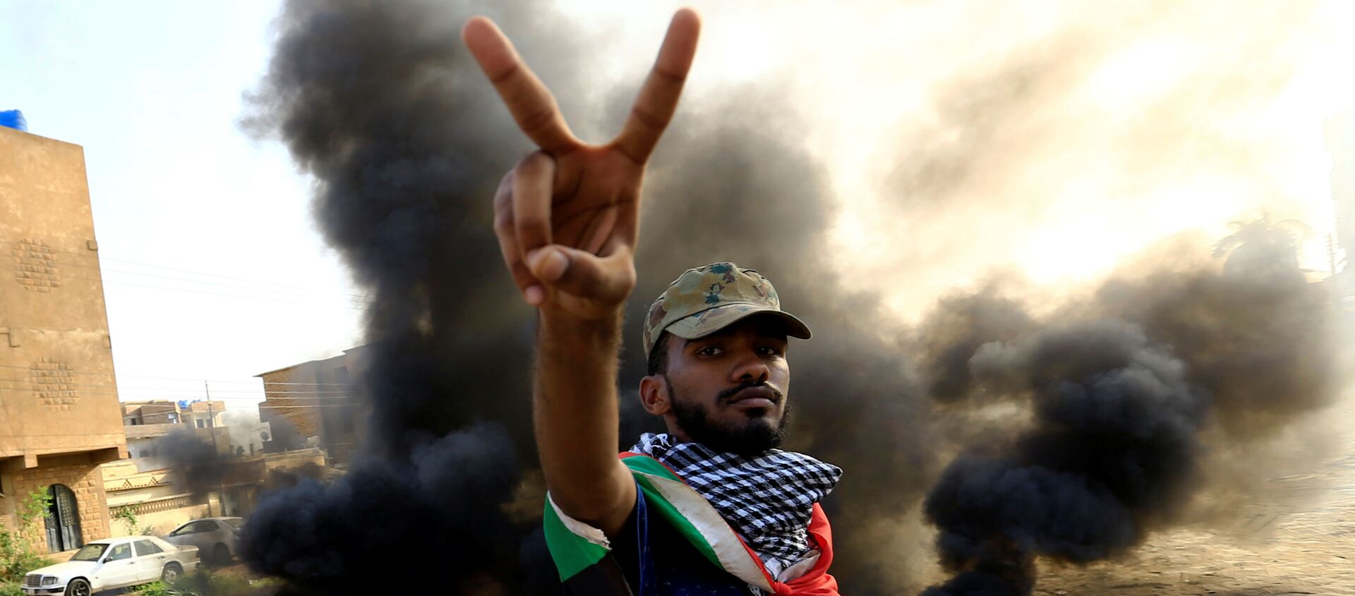 متظاهر يحرق الإطارات أثناء مظاهرة مناهضة لتقرير النائب العام عن فض الاعتصام في الخرطوم - سبوتنيك عربي, 1920, 30.07.2019