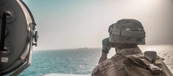 جندي من مشاة البحرية الأمريكية يراقب طائرة إيرانية هجومية من سفينة حربية أمريكية جون مورثا خلال مضيق هرمز في بحر العرب قبالة عُمان، 18 يوليو/ تموز 2019 - سبوتنيك عربي