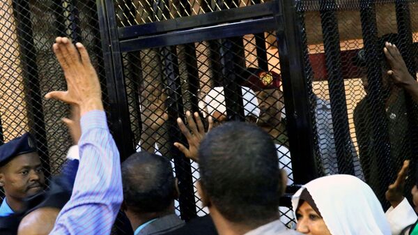 الرئيس السوداني المعزول عمر البشير داخل قفص المحاكمة  - سبوتنيك عربي