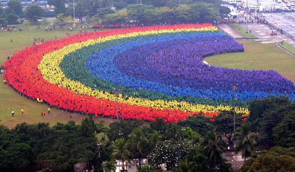قام حوالي 31 ألف طالب ومدرس وخريج من جامعة الفلبين للفنون التطبيقية بإنشاء قوس قزح بشري في حديقة مانيلا المركزية، الفلبين عام 2004 - سبوتنيك عربي