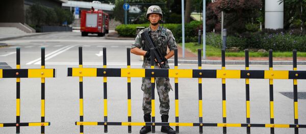 جندي صيني من جيش التحرير الشعبي يحرس مدخل مقر حامية جيش التحرير في هونغ كونغ في المنطقة التجارية المركزية في هونغ كونغ - سبوتنيك عربي