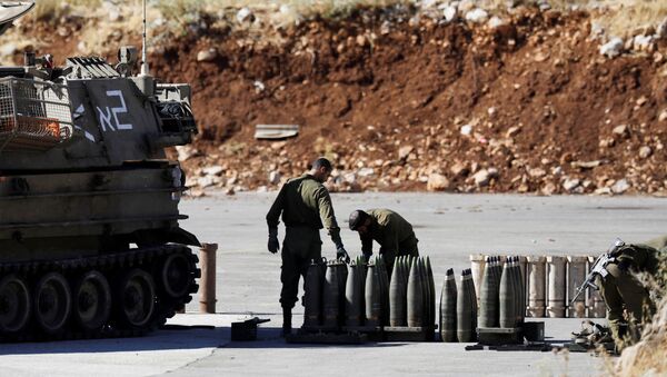 جنود إسرائيليون يقفون بجانب القذائف ووحدة مدفعية متحركة بالقرب من الجانب الإسرائيلي من الحدود مع سوريا في مرتفعات الجولان التي تحتلها إسرائيل - سبوتنيك عربي