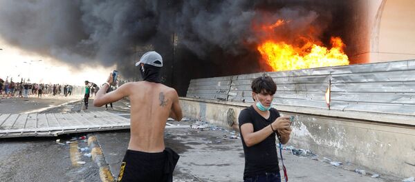 يستخدم المتظاهرون هواتفهم المحمولة خلال مظاهرة احتجاج على فساد الحكومة وسط استياء من قلة الوظائف والخدمات في بغداد - سبوتنيك عربي