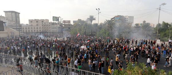 المتظاهرون يتفرقون بينما تستخدم قوات الأمن العراقية الغاز المسيل للدموع أثناء احتجاج على فساد الحكومة وسط استياء من قلة الوظائف والخدمات في ميدان التحرير في بغداد - سبوتنيك عربي