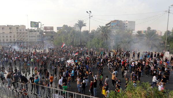المتظاهرون يتفرقون بينما تستخدم قوات الأمن العراقية الغاز المسيل للدموع أثناء احتجاج على فساد الحكومة وسط استياء من قلة الوظائف والخدمات في ميدان التحرير في بغداد - سبوتنيك عربي