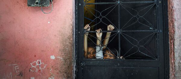 أطفال يلعبون خلف الباب، في بيتاري الفقيرة في كاراكاس، فنزويلا، 29 سبتمبر 2019 - سبوتنيك عربي