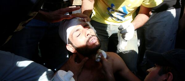 أشخاص يساعدون متظاهرا مصابا في مظاهرة أثناء حظر التجوال في بغداد، بعد 3 أيام من تحول الاحتجاجات المناهضة للحكومة إلى أعمال عنف، 4 أكتوبر/تشرين الأول 2019 - سبوتنيك عربي