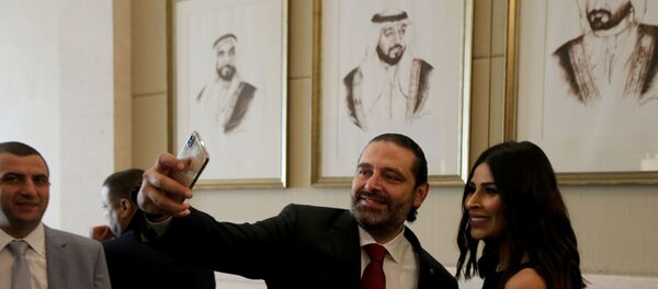رئيس الوزراء اللبناني سعد الحريري يلتقط صورة شخصية مع إحدى المشاركين في منتدى الاستثمار الإماراتي-اللبناني في أبو ظبي - سبوتنيك عربي