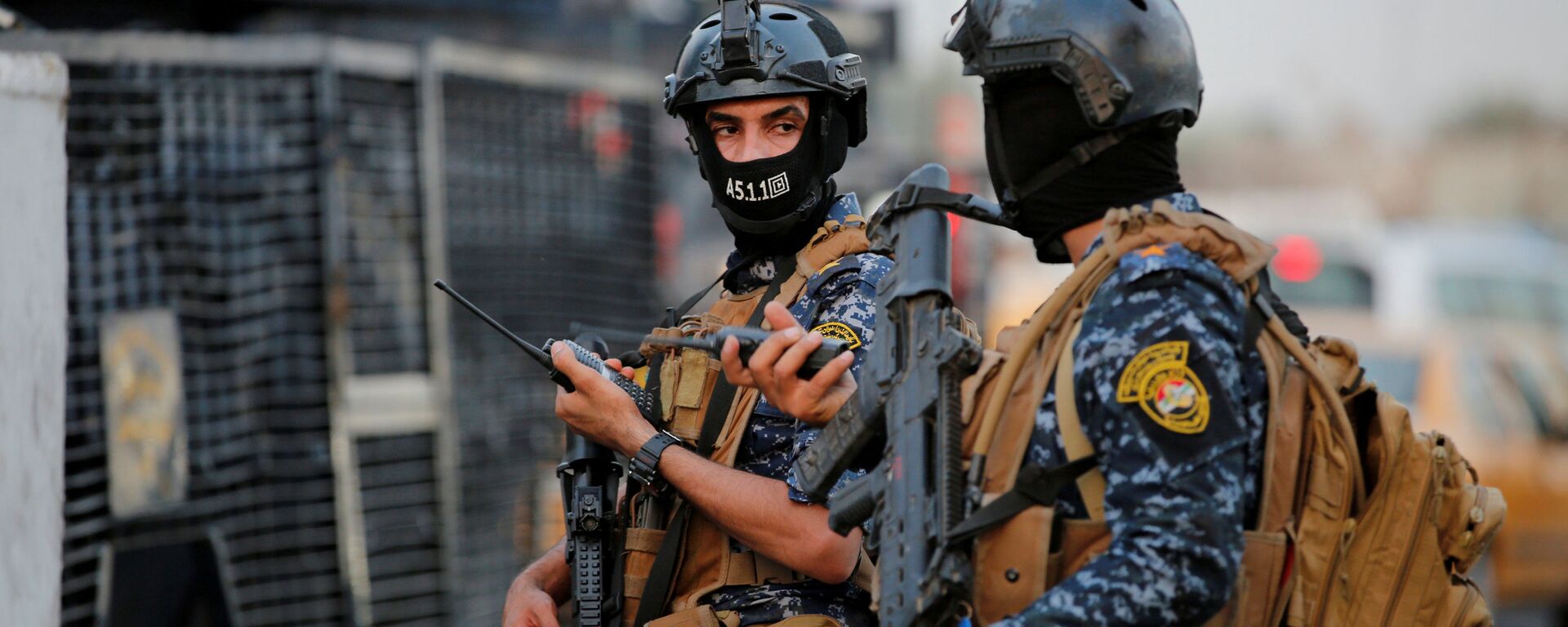 أفراد من الشرطة الفيدرالية العراقية يراقبون مركبات عسكرية في أحد شوارع بغداد، 7 أكتوبر/تشرين الأول 2019 - سبوتنيك عربي, 1920, 09.05.2021