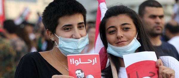 نساء لبنانيات تحملان ملصقات تحمل عبارة ارحل، وتظهر وجوه الرئيس اللبناني ميشال عون ورئيس الوزراء سعد الحريري ورئيس البرلمان نبيه بري، خلال مظاهرة خارج القصر الرئاسي في بعبدا، لبنان، 18 أكتوبر/تشرين الأول 2019 - سبوتنيك عربي