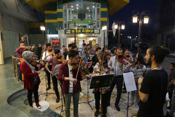 لأول مرة بعد دحر داعش... موسيقيات وعازفون عراقيون في أوركسترا مضيئة... صور+فيديو - سبوتنيك عربي