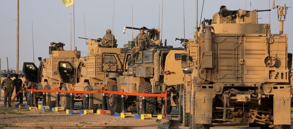 جنود أمريكيون يقفون بالقرب من شاحنات عسكرية في حقل العمر في دير الزور - سبوتنيك عربي