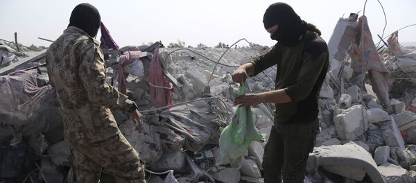 أشخاص ينظرون إلى المنازل المدمرة بالقرب من قرية باريشا في محافظة إدلب السورية بعد عملية قام بها الجيش الأمريكي وقال إنها استهدفت أبو بكر البغدادي - سبوتنيك عربي