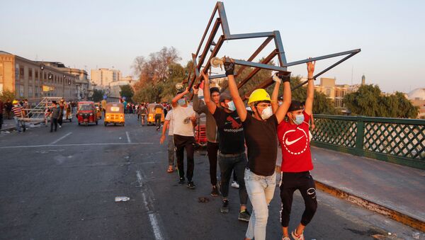 متظاهرون يقطعون جسر الأحرار خلال الاحتجاجات المستمرة المناهضة للحكومة في بغداد - سبوتنيك عربي