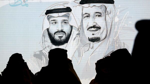 مشاركون سعوديون في مبادرة مستقبل الاستثمار يقفون لتحية النشيد الوطني أمام شاشة تعرض صورًا للملك سلمان وولي العهد الأمير محمد بن سلمان - سبوتنيك عربي
