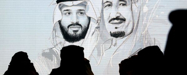 مشاركون سعوديون في مبادرة مستقبل الاستثمار يقفون لتحية النشيد الوطني أمام شاشة تعرض صورًا للملك سلمان وولي العهد الأمير محمد بن سلمان - سبوتنيك عربي