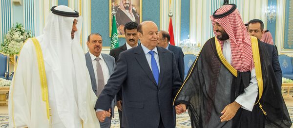 الرئيس اليمني عبد ربه منصور هادي ماسكا بيده اليمنى ولي عهد أبو ظبي الشيخ محمد بن زايد آل نهيان وبيسراه ولي العهد السعودي الأمير محمد بن سلمان أثناء التوقيع على اتفاق الرياض في السعودية - سبوتنيك عربي