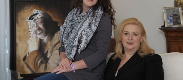 سهى عرفات وابنتها زهوة وخلفهما صورة للرئيس الفلسطيني الراحل ياسر عرفات - سبوتنيك عربي