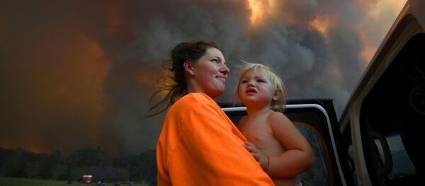 امرأة وطفلتها تنظران إلى الدخان الكثيف المتصاعد من حرائق الغابات بالقرب من منطقة نانا غلين، بالقرب من ميناء كوفس، أستراليا، 12 نوفمبر 2019 امرأة وطفلتها تنظران إلى الدخان الكثيف المتصاعد من حرائق الغابات بالقرب من منطقة نانا غلين، بالقرب من ميناء كوفس، أستراليا، 12 نوفمبر 2019 - سبوتنيك عربي