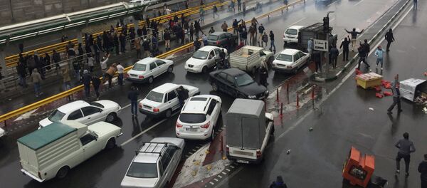 الناس يوقفون سياراتهم في طريق سريع لإظهار احتجاجهم على ارتفاع سعر الغاز في طهران - سبوتنيك عربي